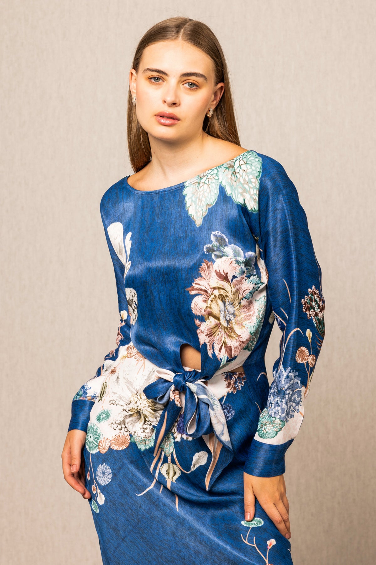 Woman wearing a blue floral dress against a beige background