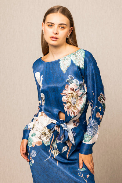 Woman wearing a blue floral dress against a beige background