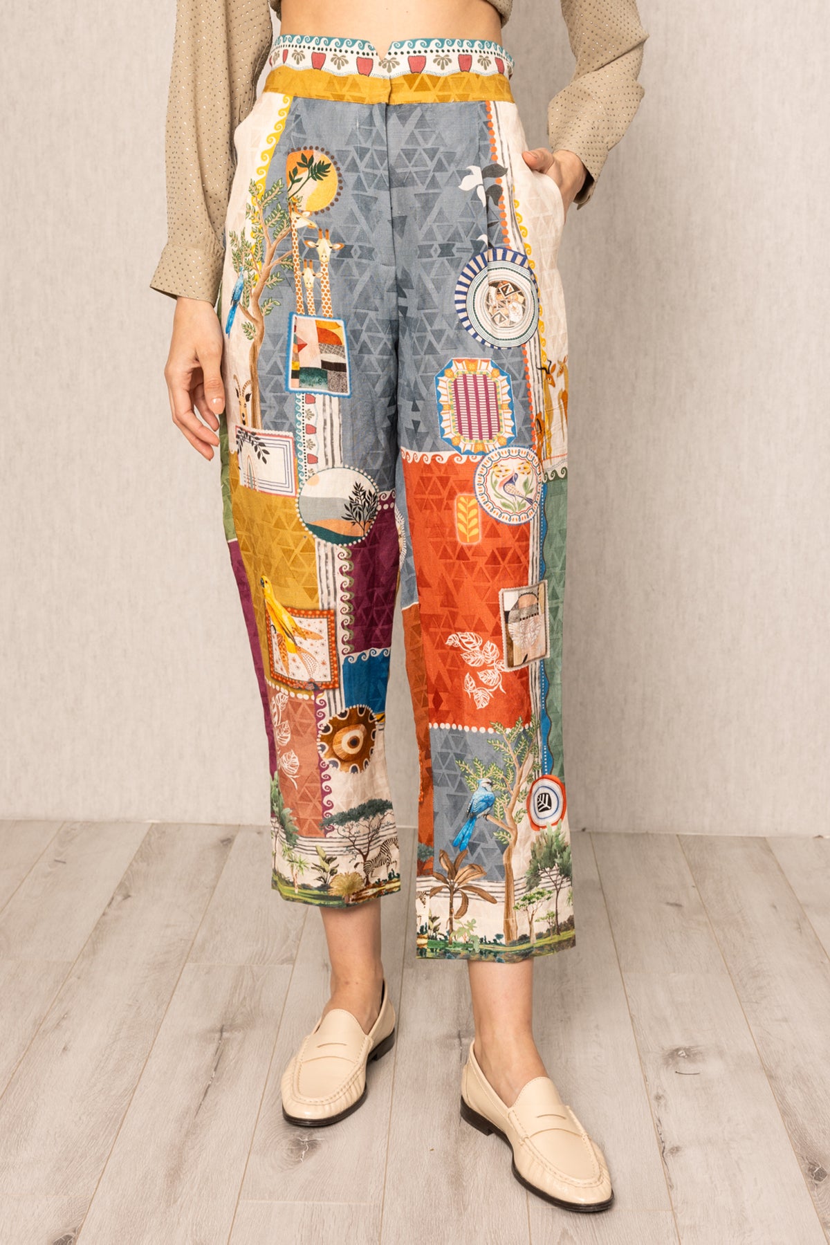 Person wearing colorful patchwork pants on a plain background