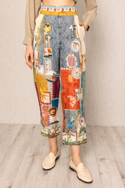 Person wearing colorful patchwork pants on a plain background