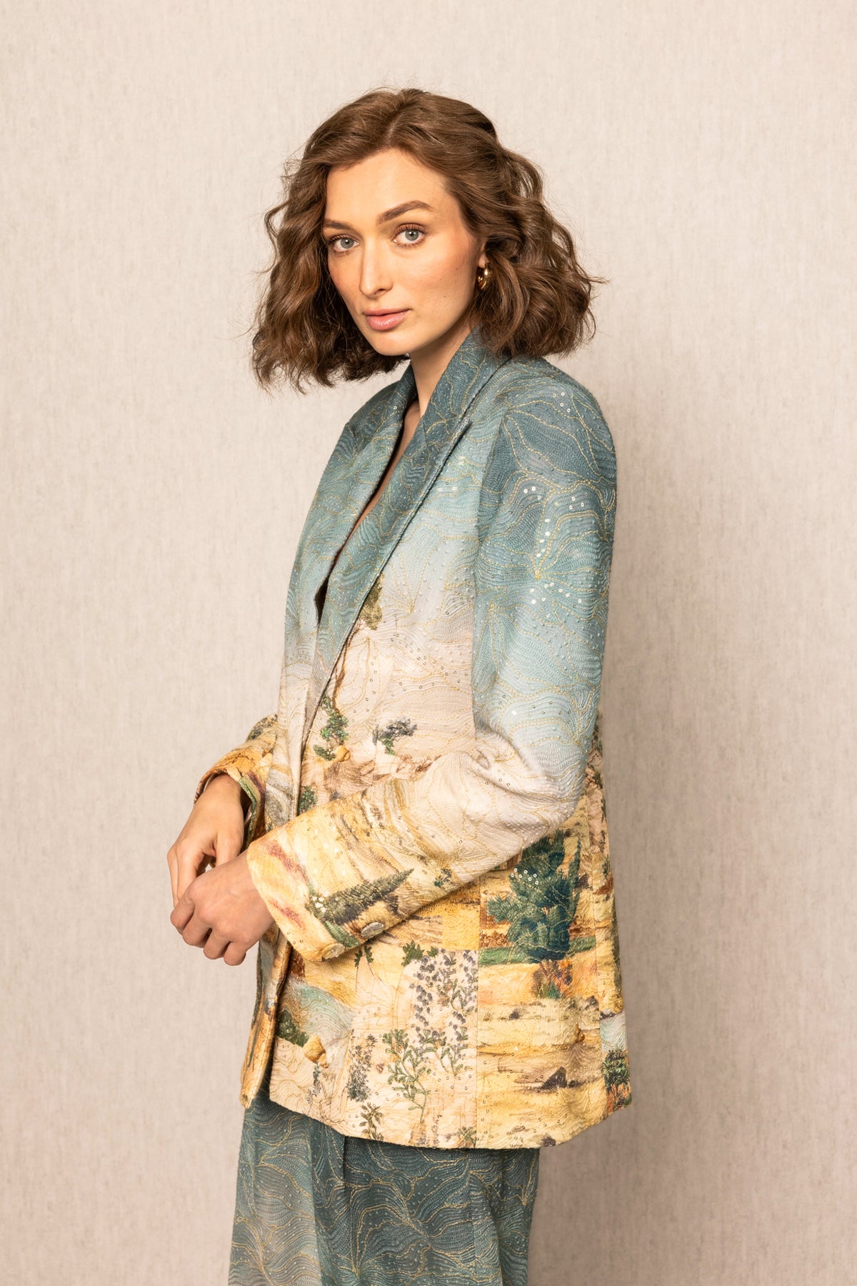 Woman wearing a patterned blazer against a plain background