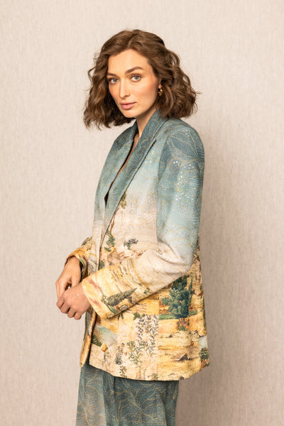Woman wearing a patterned blazer against a plain background