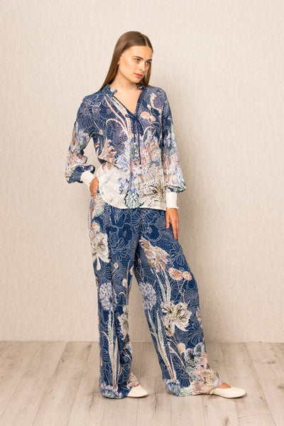Woman wearing a blue floral pajama set on a plain background
