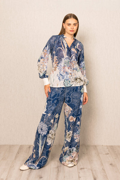 Woman wearing a blue floral pajama set against a plain background
