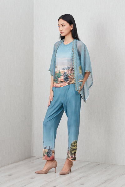 Woman wearing a blue outfit with floral patterns on a plain background